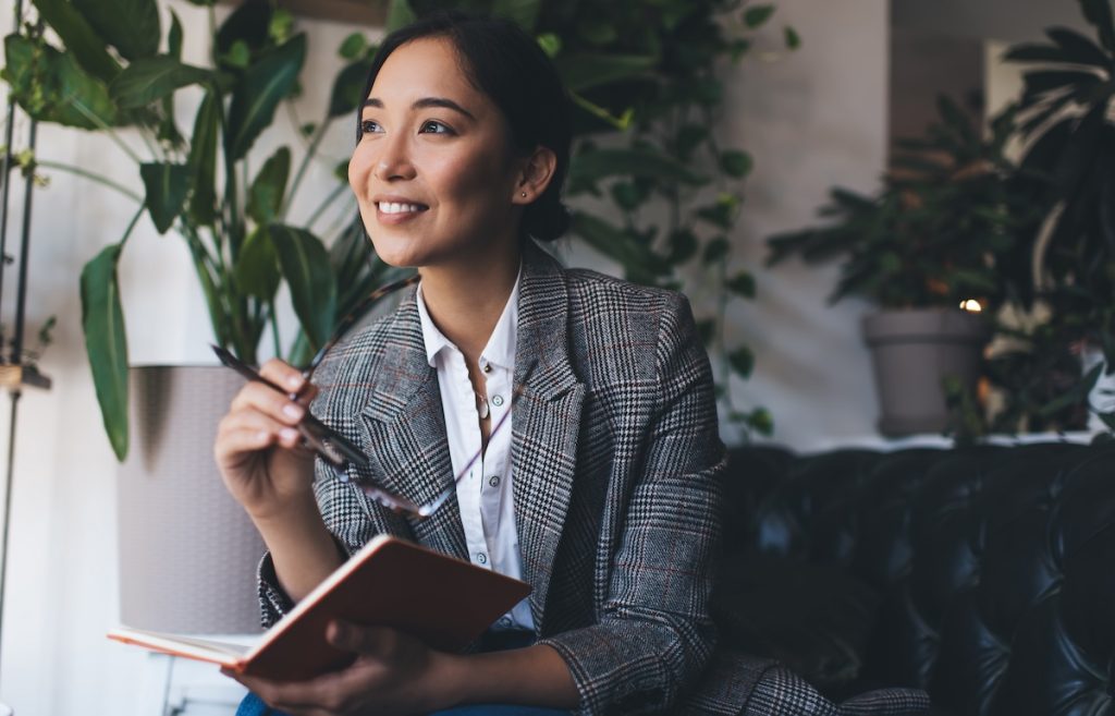 Woman sitting in cafe with note pad