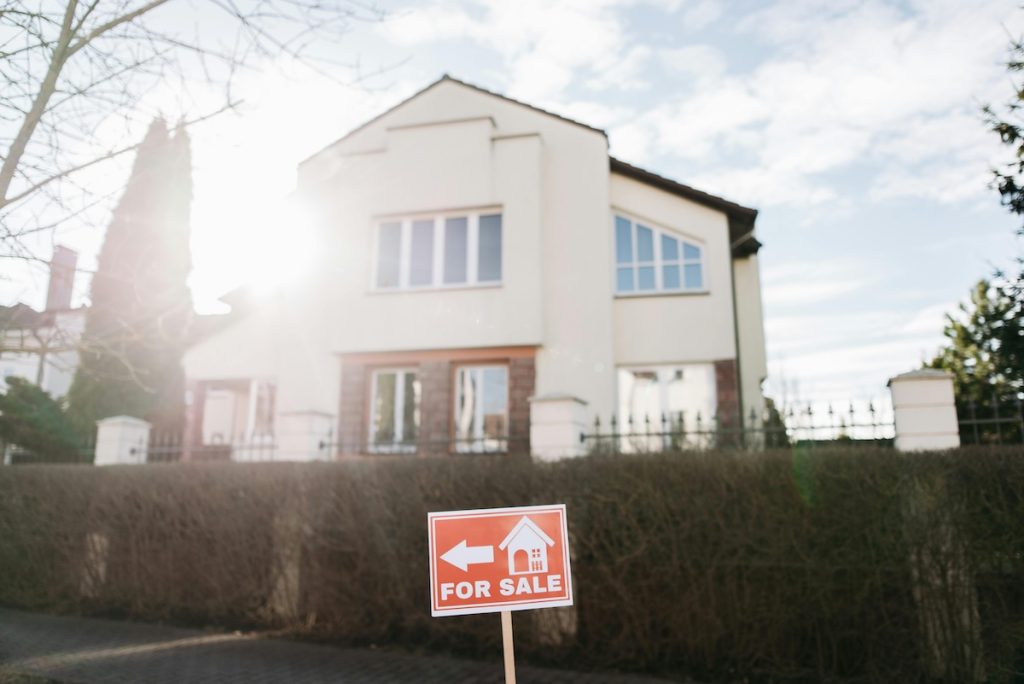House with for sale sign in front of it.