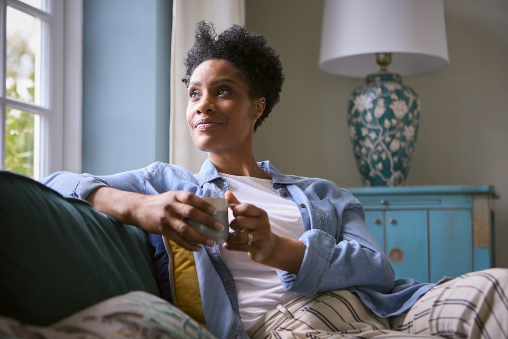 Mature thoughtful woman sitting on couch