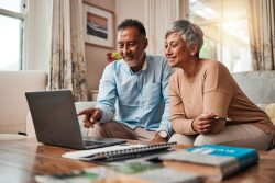 Mature happy couple on couch in front of laptop