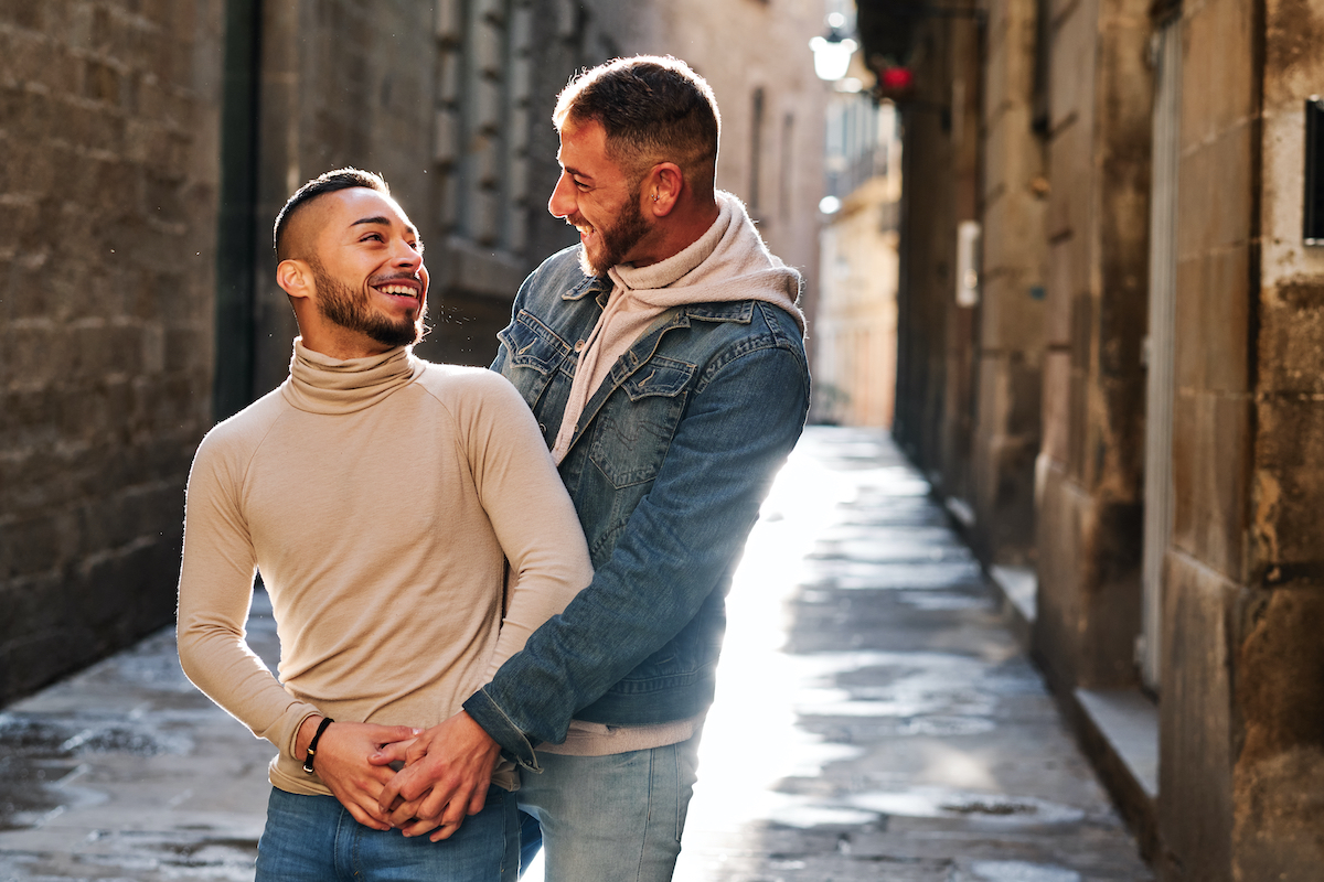 Gay couple embracing in street
